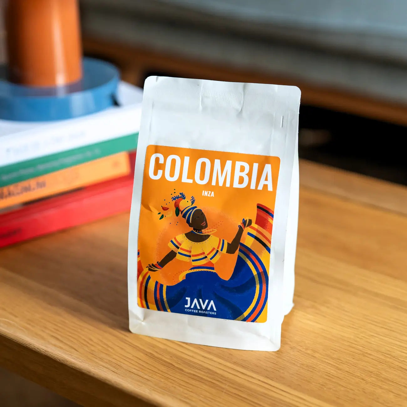 Kawa Java Coffee Colombia Inza – paczka kawy specialty z pomarańczową etykietą, ustawiona na drewnianym stole