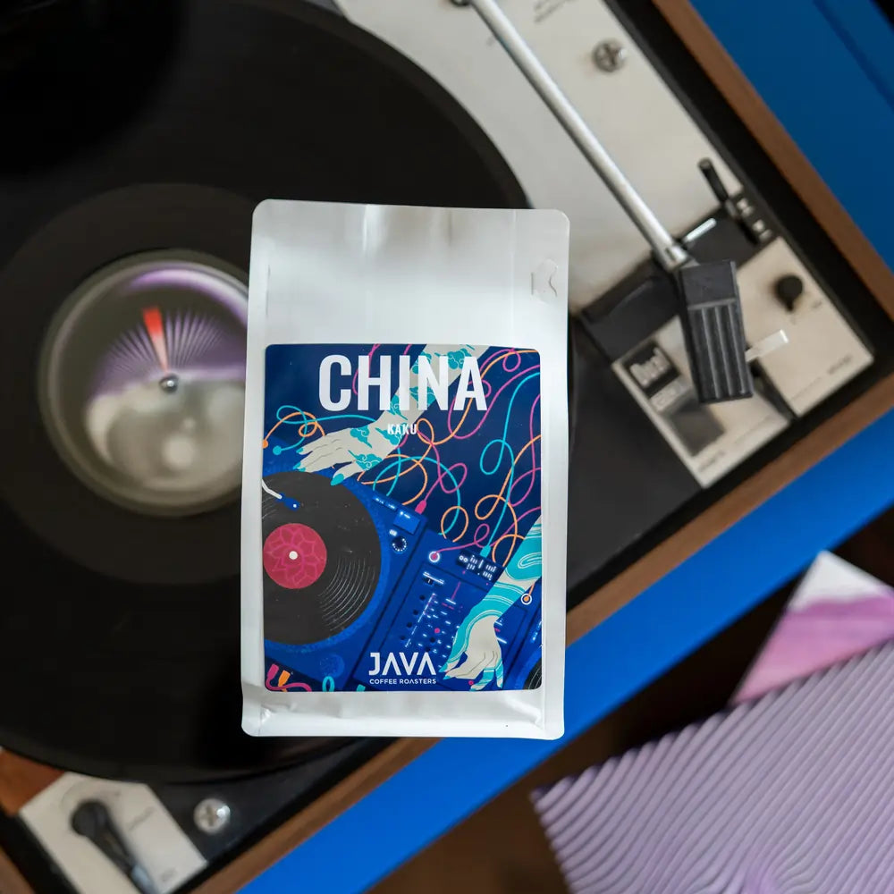 Kawa China Kaku JAVA Coffee Roasters – opakowanie kawy ziarnistej na tle gramofonu, arabica z Chin do espresso w gastronomii