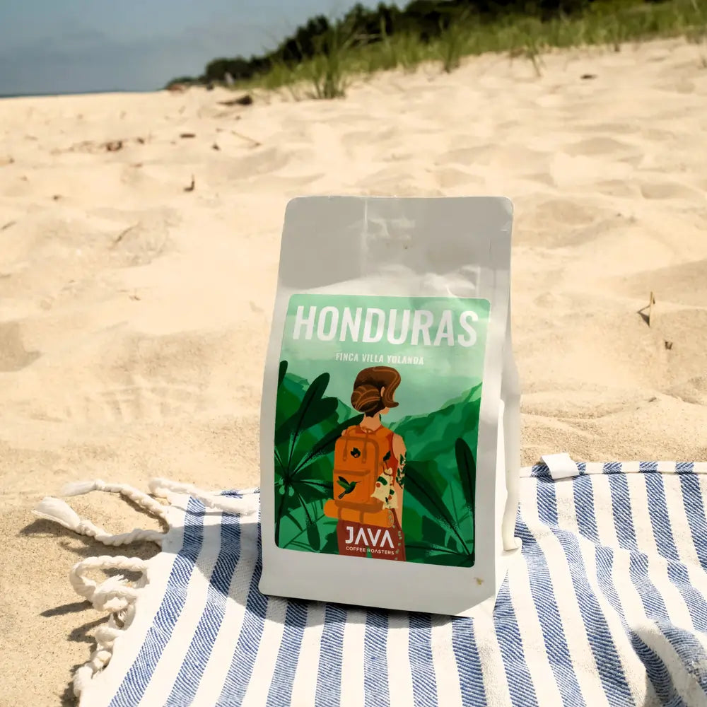 Kawa ziarnista Honduras Finca Villa Yolanda 250 g JAVA Coffee Roasters – specialty Arabica, opakowanie na plaży w scenerii lifestyle