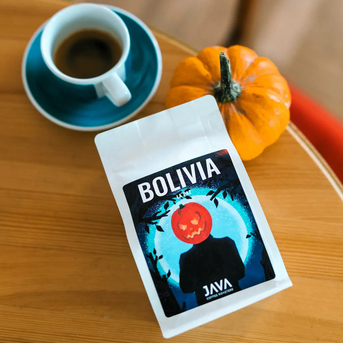 Kawa specialty Bolivia La Paz od JAVA Coffee Roasters – opakowanie kawy z Boliwii obok filiżanki naparu i dyni.