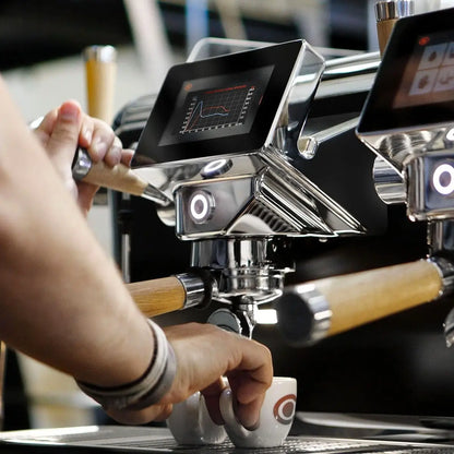 Astoria Storm – barista podczas ekstrakcji espresso, ekran kontrolny i kolba z drewnianą rączką, profesjonalny ekspres Astoria Storm w kawiarni
