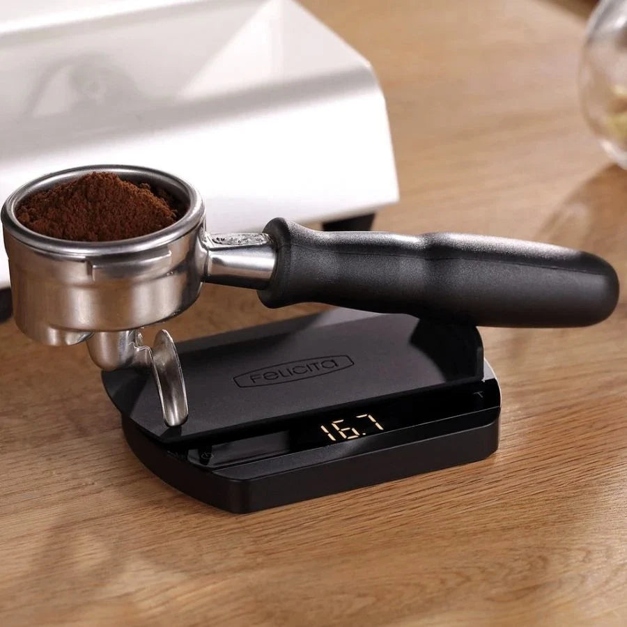 Waga baristyczna Felicita Arc z portafiltrem i odmierzoną porcją kawy do espresso