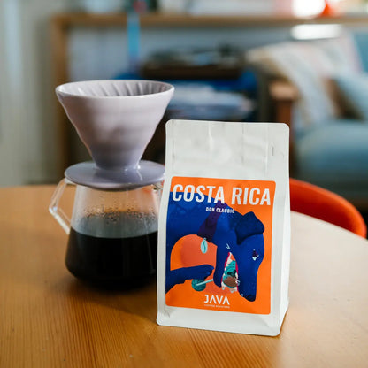Kawa specialty Costa Rica Don Claudio od JAVA Coffee Roasters – opakowanie obok drippera i świeżo zaparzonej kawy, zdjęcie lifestyle