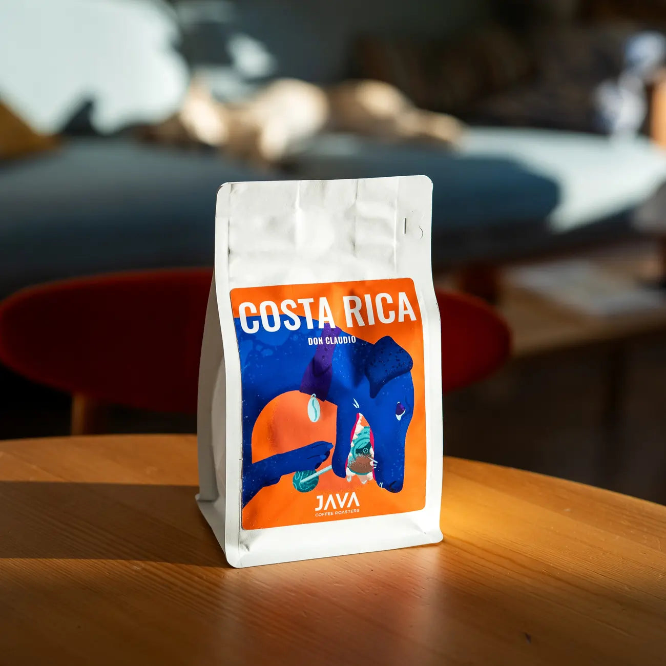 Kawa specialty Costa Rica Don Claudio od JAVA Coffee Roasters – opakowanie na drewnianym stoliku w kawiarni, zdjęcie lifestyle
