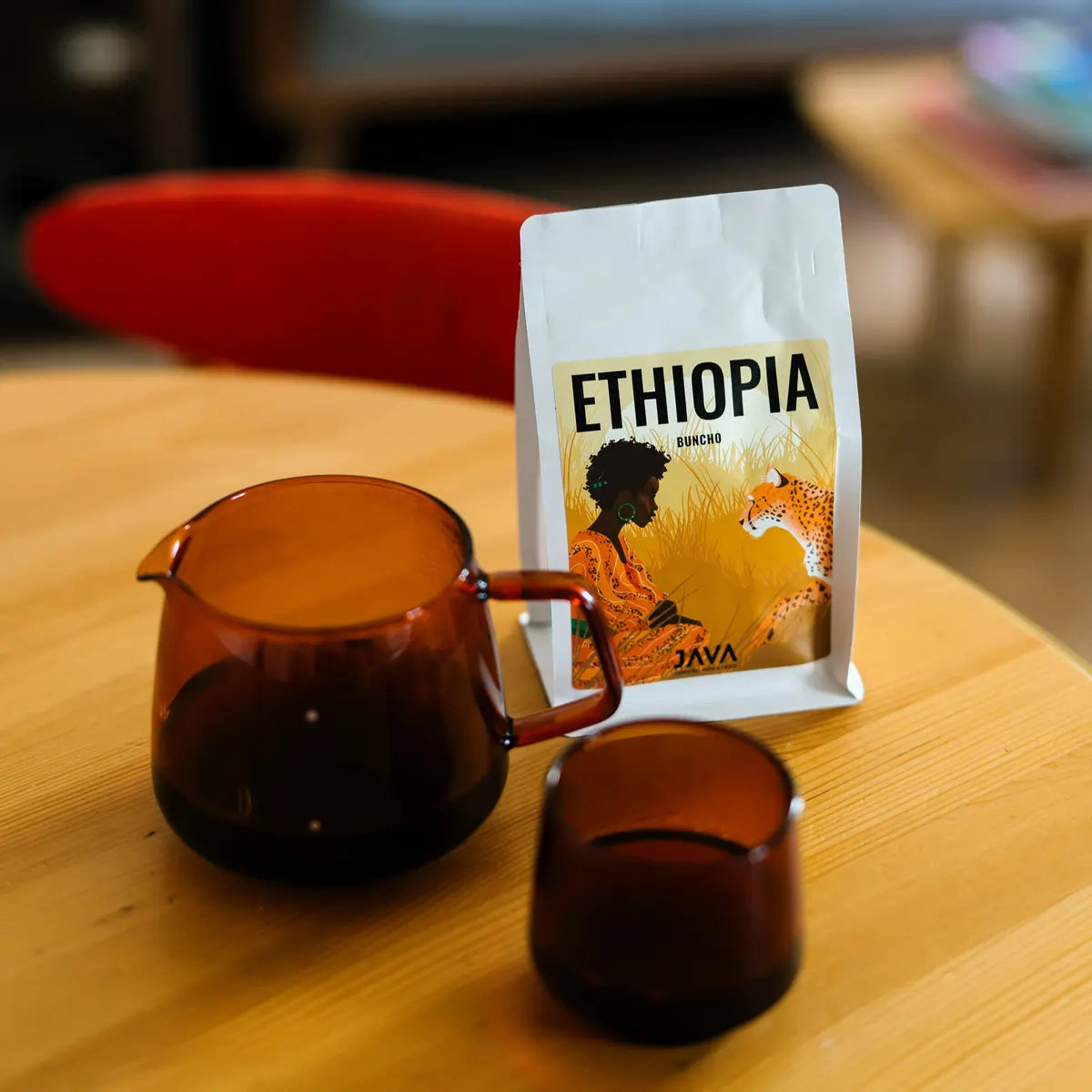 Opakowanie kawy JAVA Coffee Ethiopia Buncho obok szklanego serwera i filiżanki – świeżo palona kawa specialty z warszawskiej palarni