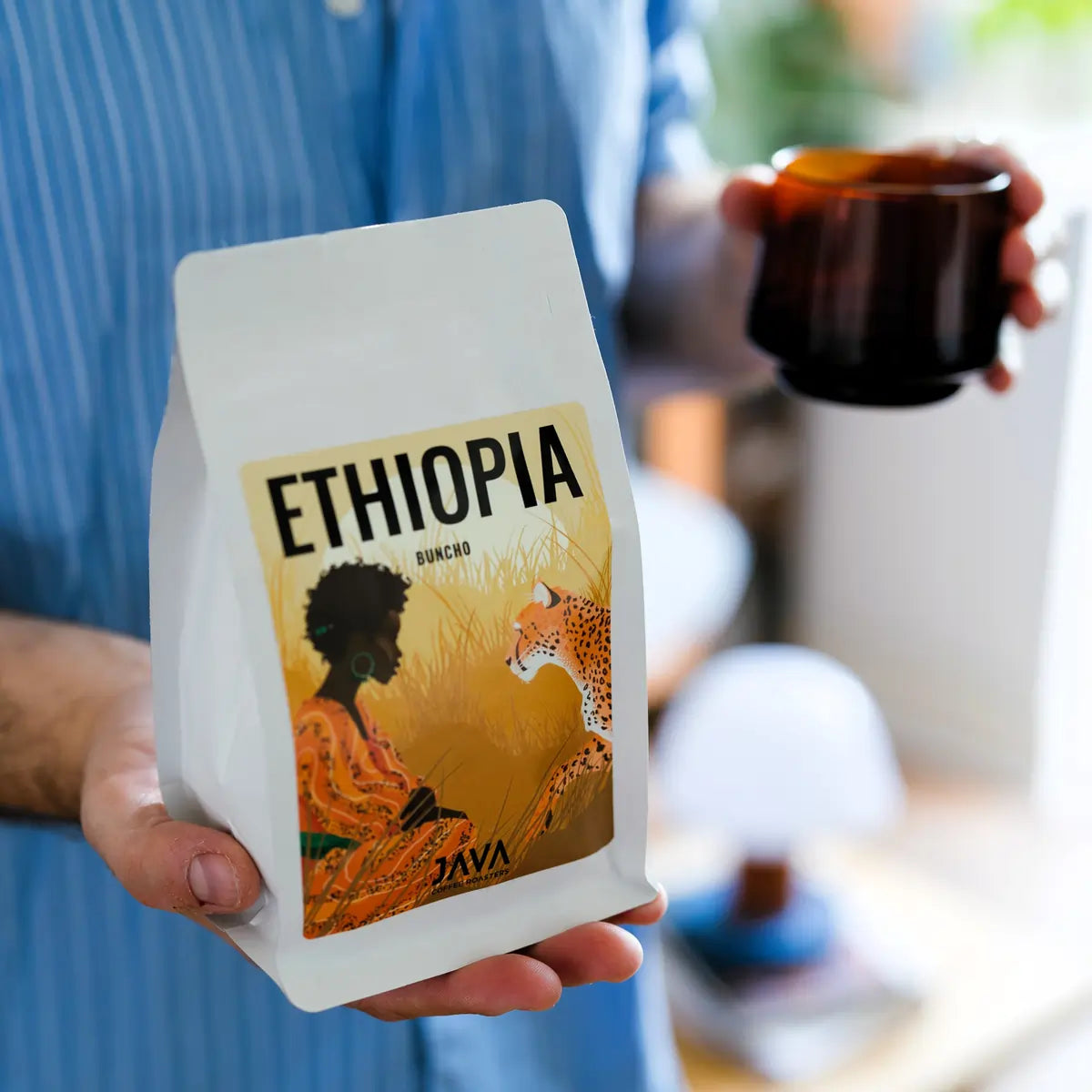 Opakowanie kawy JAVA Coffee Ethiopia Buncho trzymane w dłoni podczas parzenia kawy – świeżo palona kawa specialty z warszawskiej palarni