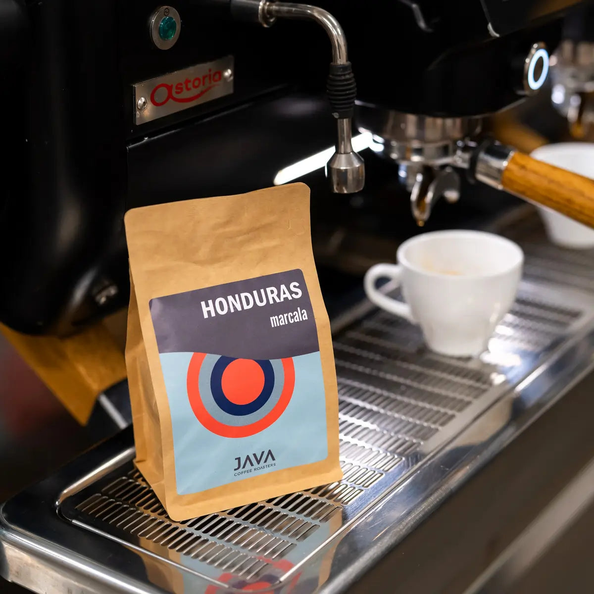 Kawa specialty Honduras Marcala od JAVA Coffee Roasters ustawiona przy profesjonalnym ekspresie ciśnieniowym do espresso.