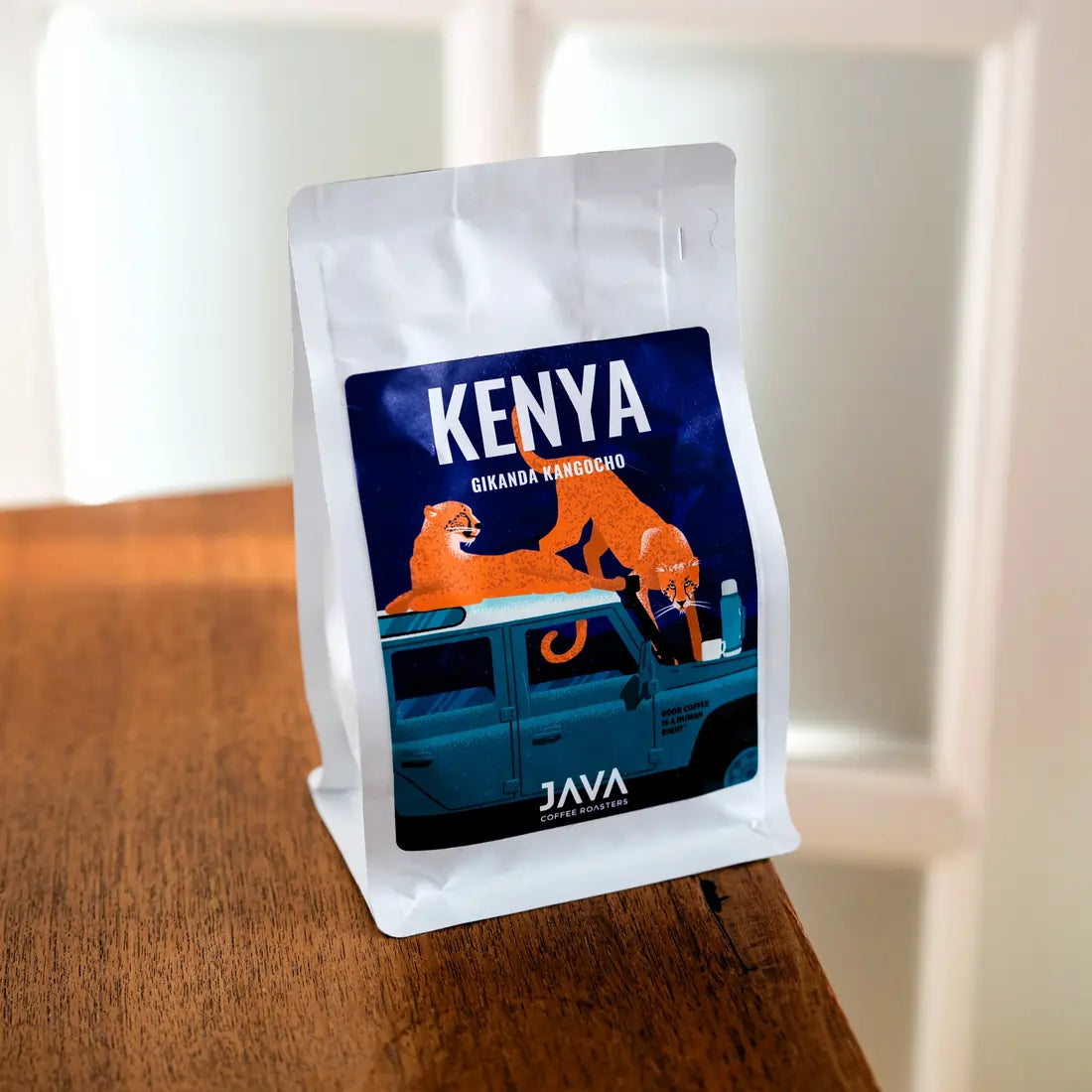 Kawa ziarnista Kenya Gikanda Kangoch od JAVA Coffee Roasters – opakowanie kawy ustawione na drewnianym stole, minimalistyczne lifestyle zdjęcie w naturalnym świetle.