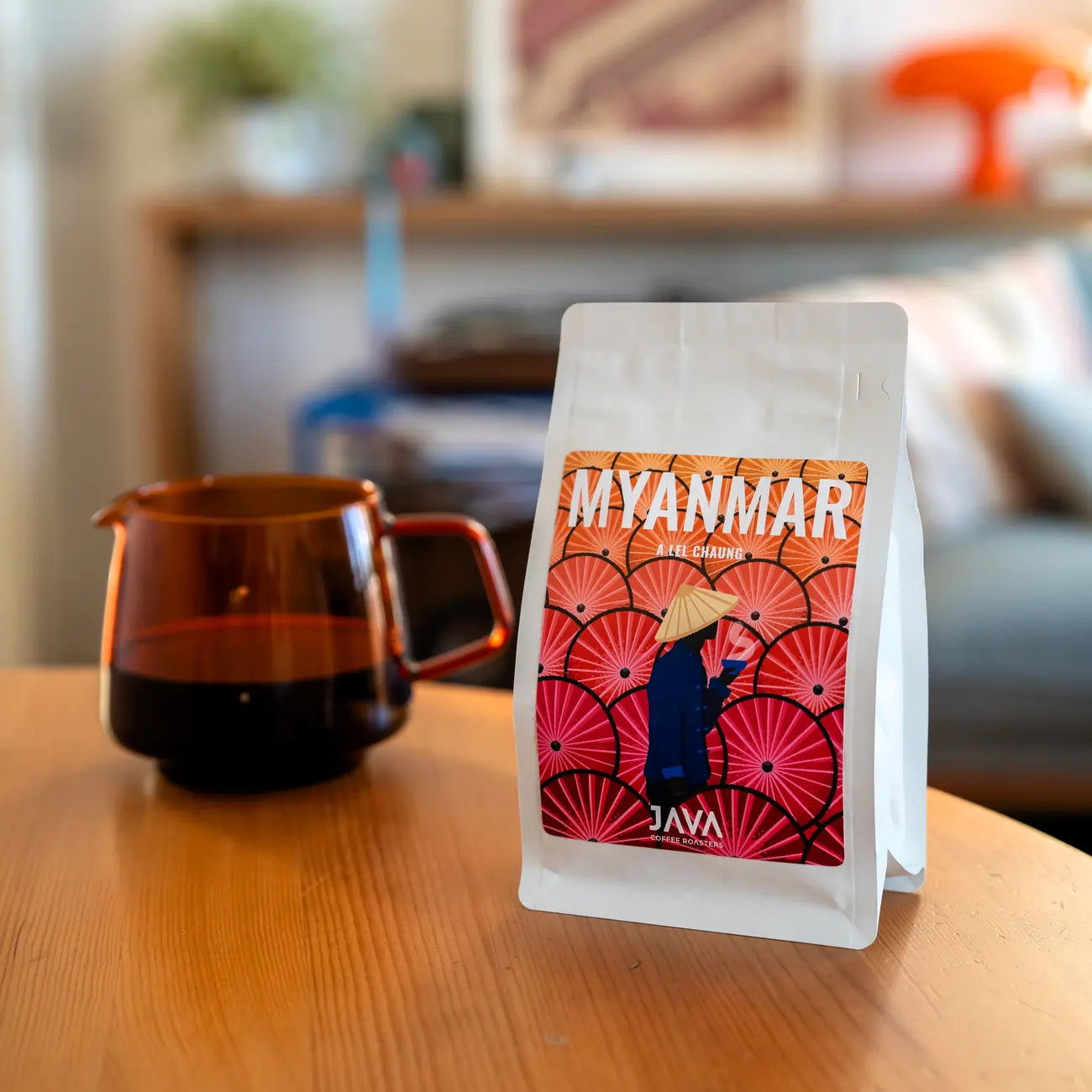 Opakowanie kawy JAVA Coffee Roasters Myanmar A Lei Chaung na drewnianym stole w domowym wnętrzu