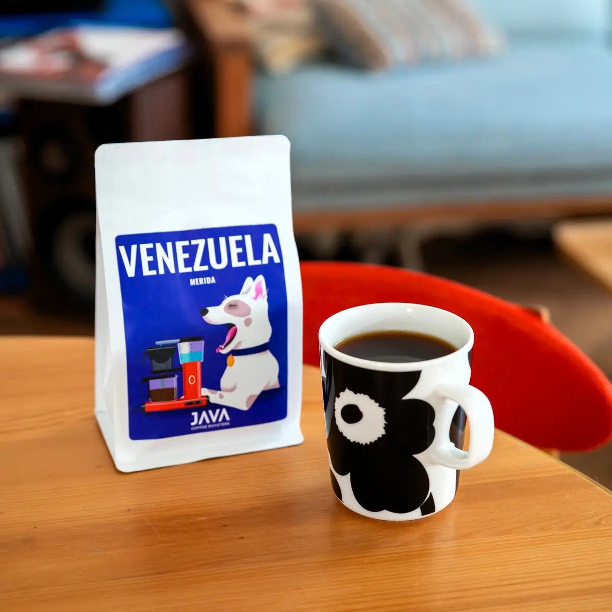 Kawa ziarnista Venezuela Merida 250g JAVA Coffee Roasters obok filiżanki czarnej kawy na stole