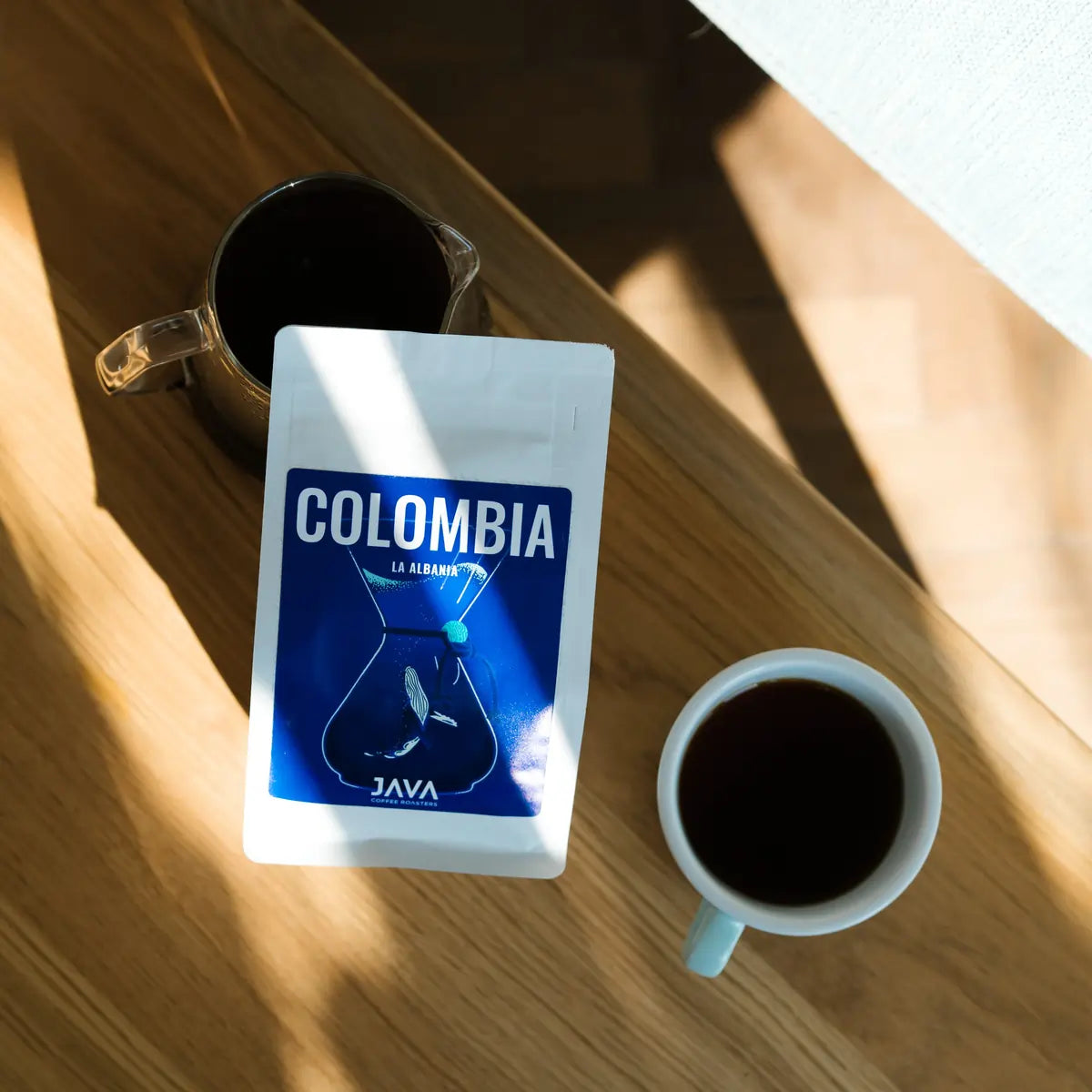 Kawa speciality Java Coffee Roasters Colombia La Albania widok z góry na stole z filiżanką i dzbankiem kawy