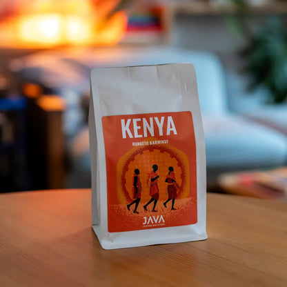 Kawa ziarnista Kenya Rungeto Karimikui JAVA Coffee Roasters w białym opakowaniu, zdjęcie lifestyle na drewnianym stole w domowym wnętrzu
