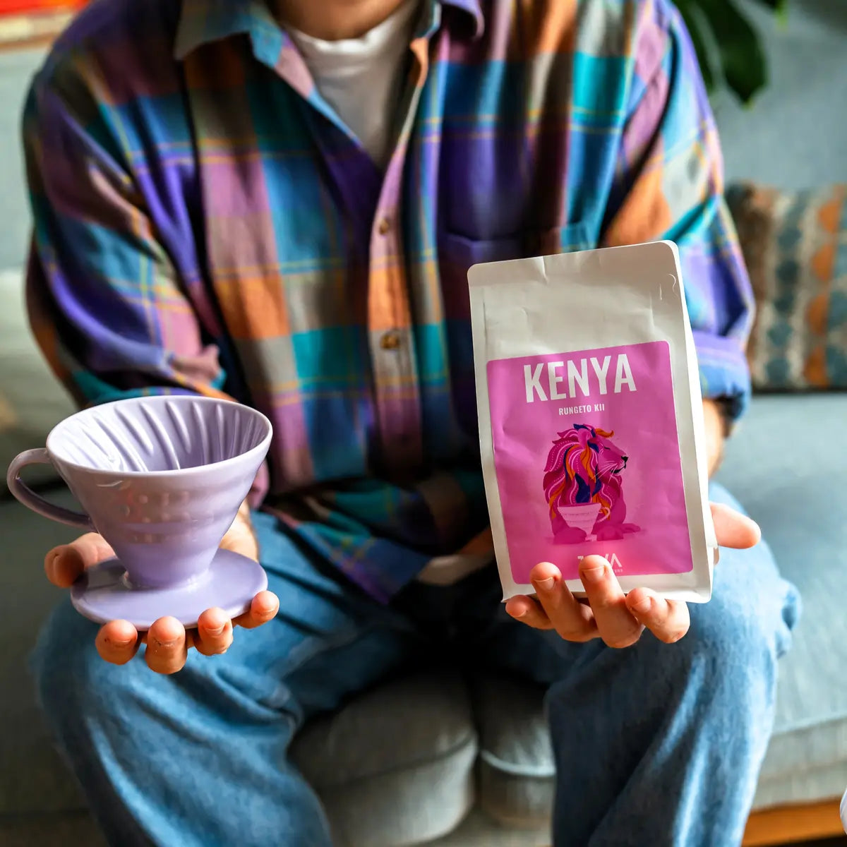 Kawa specialty Kenya Rungeto Kii od JAVA Coffee Roasters – opakowanie kawy trzymane w dłoni obok drippera, zdjęcie lifestyle prezentujące kawę do metod przelewowych