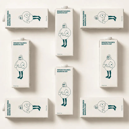 Flat lay przedstawiający opakowania Minor Figures Barista Oat Gluten Free 1L na jasnym tle – bezglutenowy napój owsiany do kawy specialty