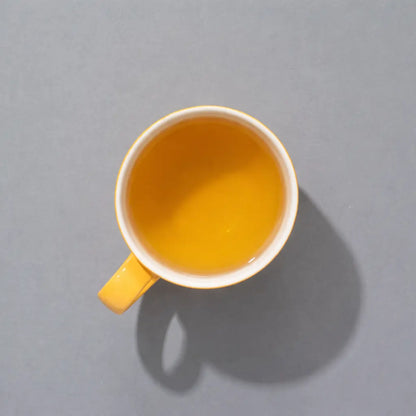 Herbata ziołowa SUKI Tea – złocisty napar w filiżance, widok z góry