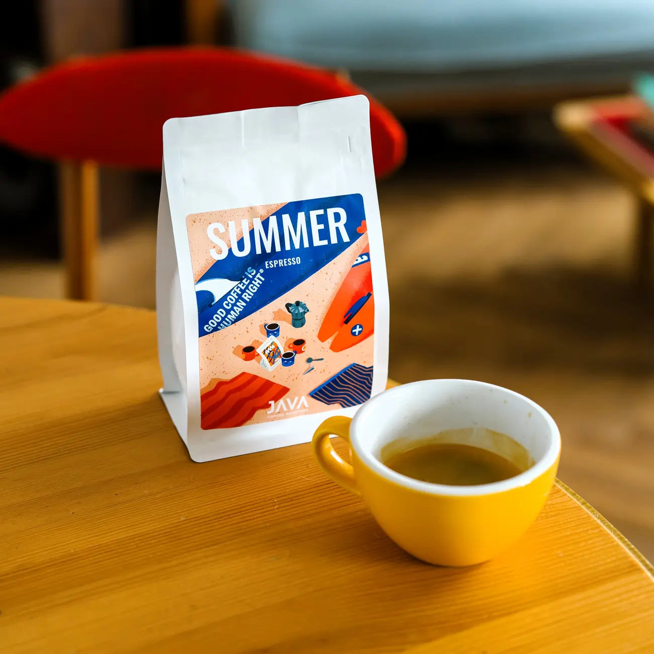 Kawa Summer Espresso od JAVA Coffee Roasters obok filiżanki espresso na stoliku w kawiarni