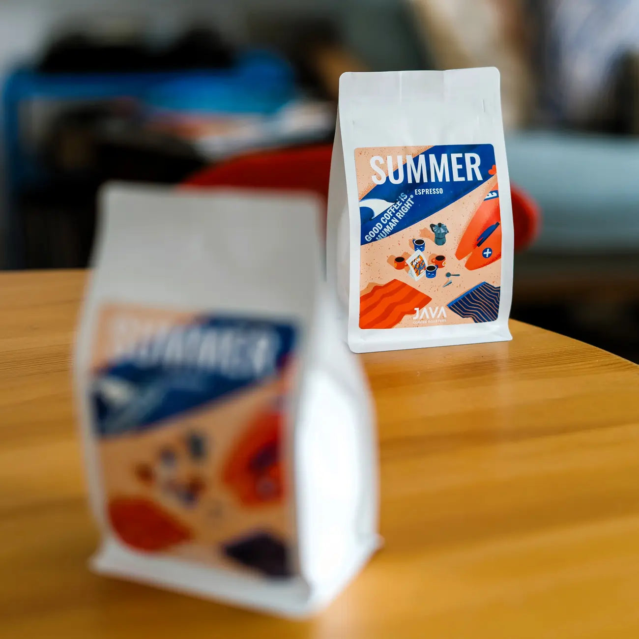 Opakowania Summer Espresso od JAVA Coffee Roasters na stoliku w kawiarni – kawa specialty dla gastronomii, biur i hoteli