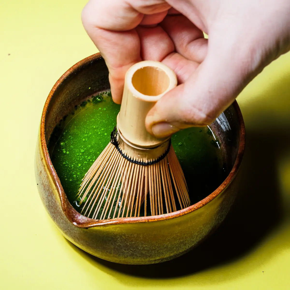 Przygotowanie YŌKIRO Matcha Superior – ubijanie ceremonialnej matchy bambusową trzepaczką chasen w tradycyjnej czarce, kremowa konsystencja i intensywnie zielony napar.